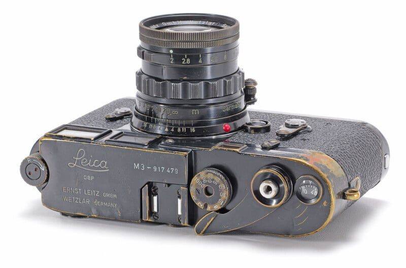 An early Leica M3 in black paint with a black frame counter, showing honest brassing, which sold for 187,500 euros at Wetzlar.